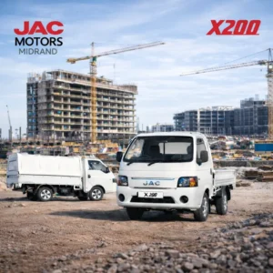 Two white JAC X200 workhorse trucks parked at a busy construction site with cranes and buildings.